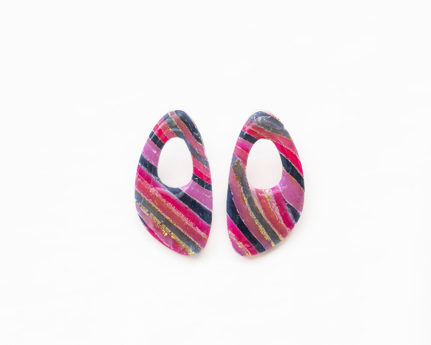 Aros de autor Taller Carolina en tonos magenta y gris con pan de oro, diseño ovalado calado artesanal.