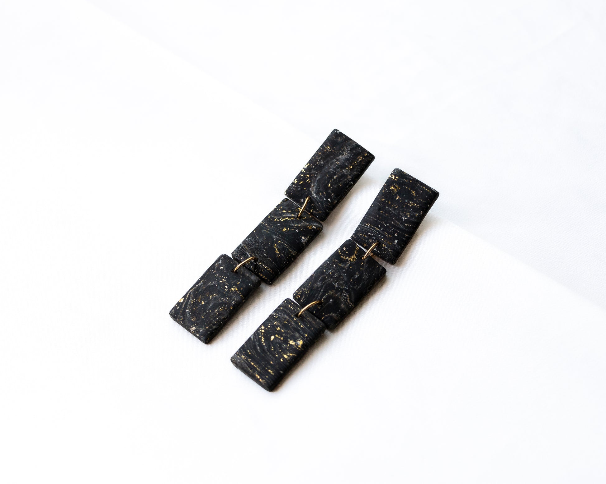 Aros colgantes rectángulos articulados arcilla polimérica negro pan de oro hechos a mano Santiago Chile