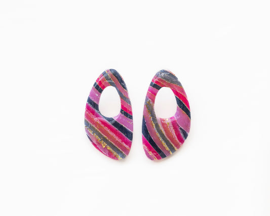 Aros de autor Taller Carolina en tonos magenta y gris con pan de oro, diseño ovalado calado artesanal.